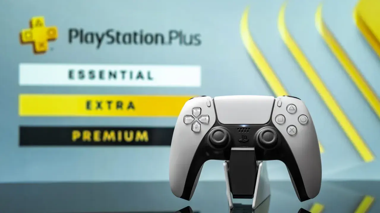 Biały kontroler DualSense na tle menu PlayStation Plus z opcjami Essential, Extra i Premium.