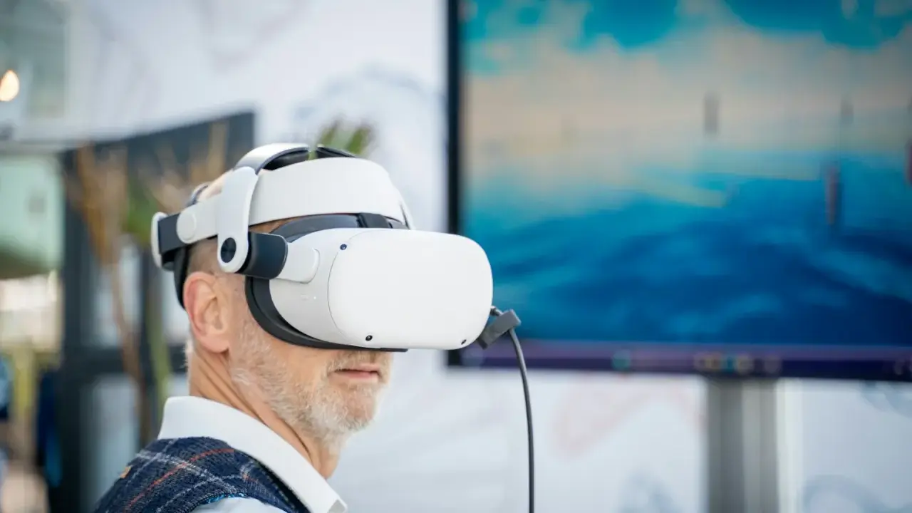 Mężczyzna w goglach VR zanurza się w wirtualnym świecie. Komputer do VR pozwala mu doświadczyć niesamowitych wrażeń.