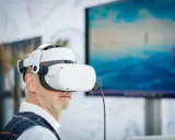 Mężczyzna w goglach VR zanurza się w wirtualnym świecie. Komputer do VR pozwala mu doświadczyć niesamowitych wrażeń.