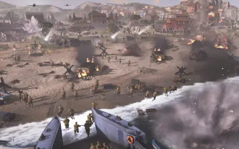 Desant na plażę w Company of Heroes. Żołnierze szturmują brzeg, płoną pojazdy, w tle miasto.