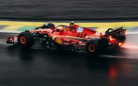 Czerwony bolid F1 2018 z numerem 55 na torze, w deszczu.