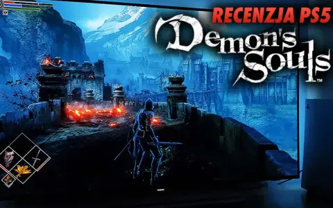 Rycerz w zbroi na moście przed zamkiem, płomienie i góry w tle. Napis "Demon's Souls" i "Recenzja PS5".