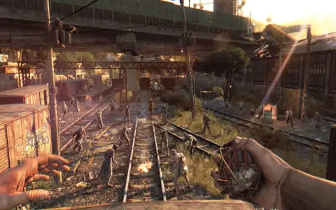 Gracz trzyma granat, otoczony przez hordę zombie na torach kolejowych. To scena z gry Dying Light, gdzie wymagania sprzętowe są kluczowe dla płynności rozgrywki.