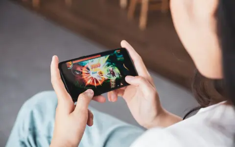 Osoba gra w ekscytujące gry multiplayer na telefonie, walcząc z potężnym przeciwnikiem.