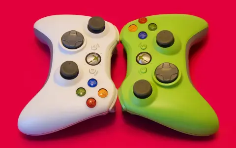 Biały i zielony kontroler Xbox 360 obok siebie. Idealne do gier strategicznych w czasie rzeczywistym, wymagających szybkiego myślenia i precyzji.