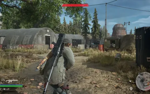 Gracz w Days Gone Remastered z karabinem na plecach przemierza obóz z namiotami i kontenerami.