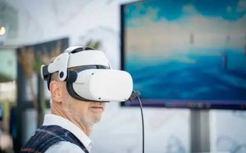Mężczyzna w goglach VR zanurza się w wirtualnym świecie. Komputer do VR pozwala mu doświadczyć niesamowitych wrażeń.
