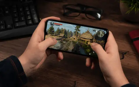 Ręce trzymają smartfon z grą akcji w stylu fantasy. To jedna z najlepszych gier mobilnych.