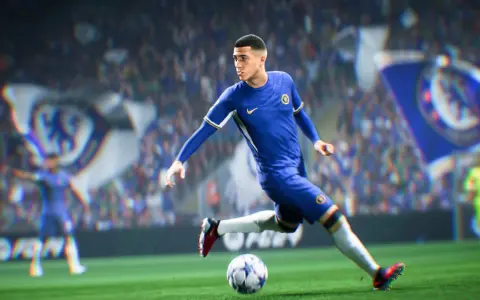 Piłkarz w niebieskiej koszulce Chelsea drybluje piłką na boisku, gotowy do strzału w grze FIFA 2k.