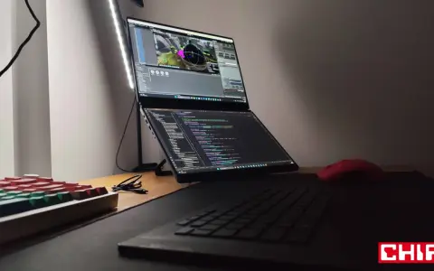Na biurku laptop z dwoma ekranami, na górnym widać scenę w Unreal Engine 6, na dolnym kod. Obok klawiatura i czerwona myszka.