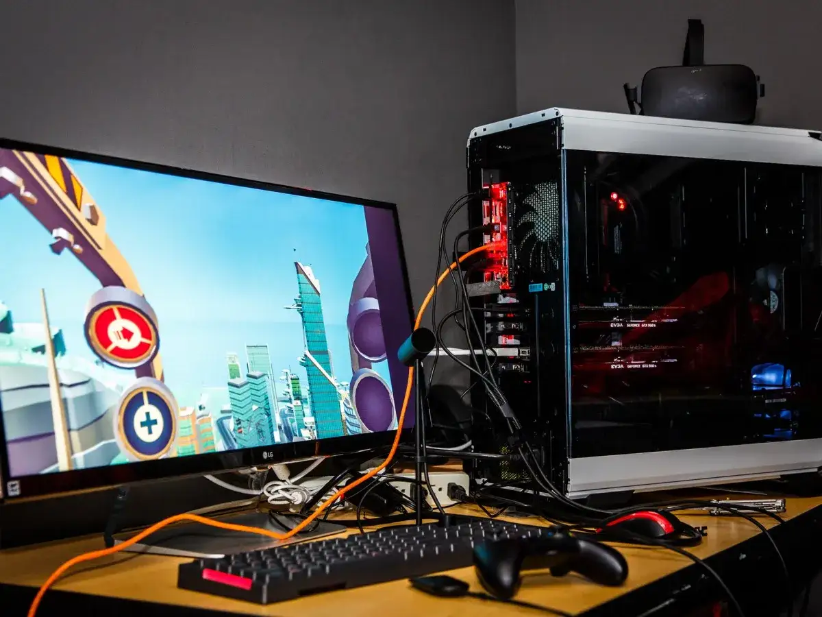 Potężny komputer do VR z kartami graficznymi EVGA, monitorem z grą i goglami VR na obudowie.