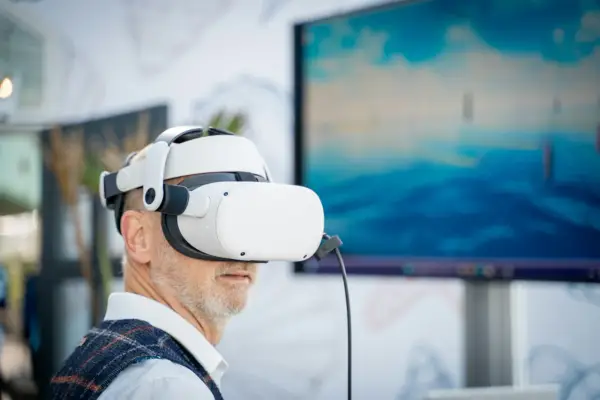 Mężczyzna w goglach VR zanurza się w wirtualnym świecie. Komputer do VR pozwala mu doświadczyć niesamowitych wrażeń.